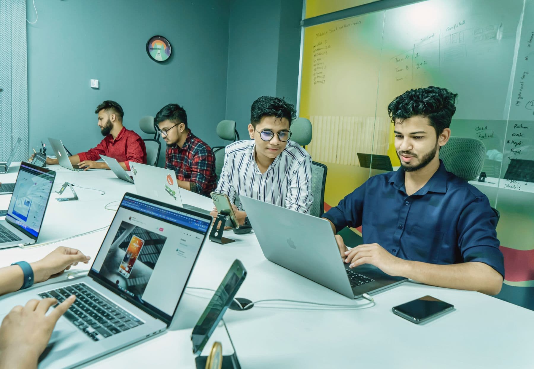 Team collaborating on laptops in an office
