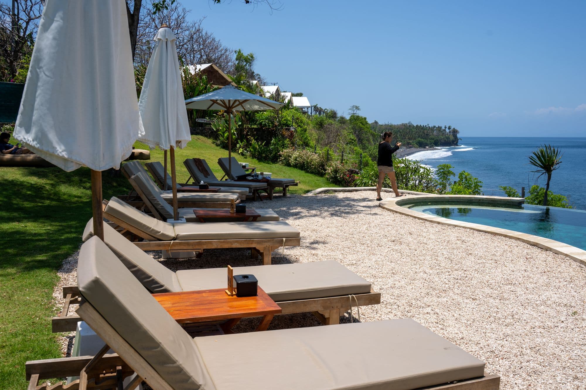 Sun loungers by a resort pool overlooking the ocean in Bali